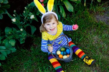 Cute little toddler girl with bunny ears having fun with...