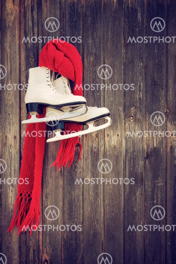 Old ice skates hanging on rustic wooden wall