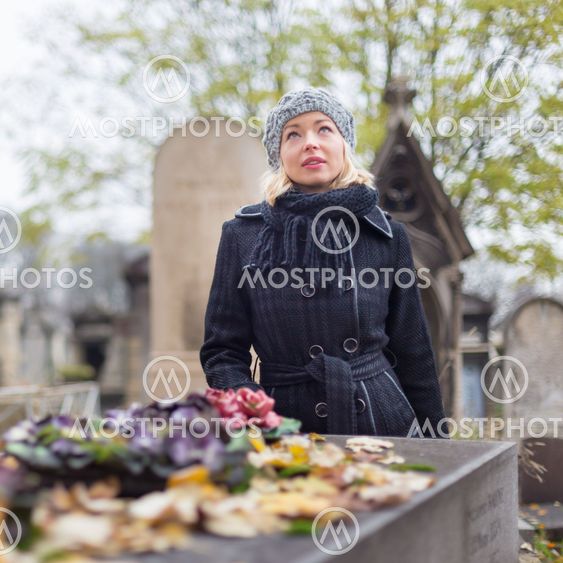 Solitary woman visiting relatives grave.