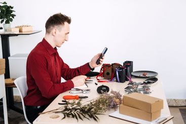 Young Eastern European man photographing handmade...