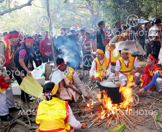 People in traditional costume exam to make round sticky...