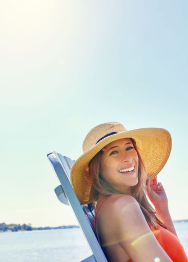 Portrait, seaside and woman with hat, travel and smile...