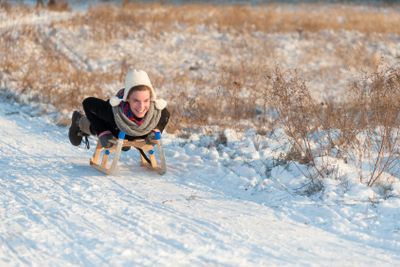 Attractive woman woman tobogganing downhill