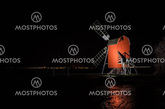 Red old traditional windmill by night