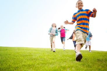 Adventure, running and group of children in field for...