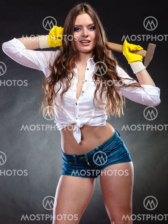 Sexy alluring woman holding hammer. Feminism.
