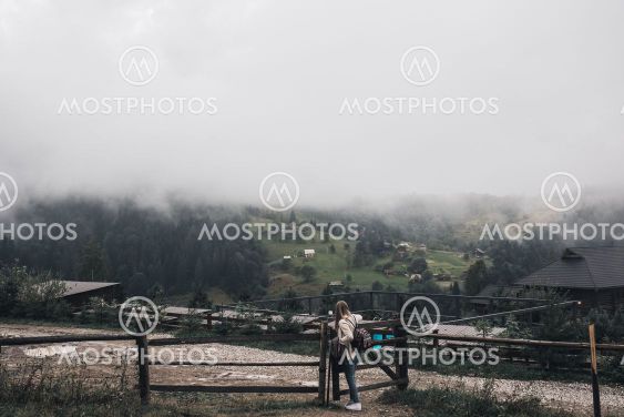 woman traveler near old fence against Carpathian...