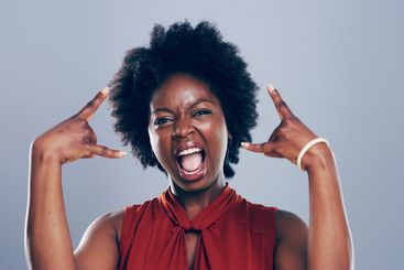 Portrait, smile or black woman in studio with rock hand...