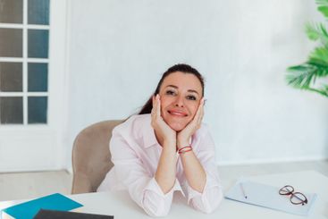 Brunette businesswoman sitting at desk in office and...