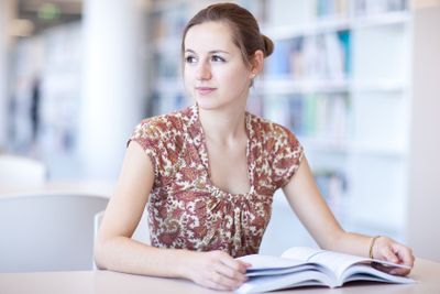 pretty young college student in a library (shallow DOF;...