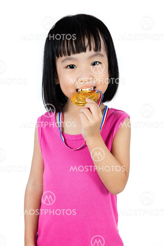 Asian Chinese little girl biting gold medal