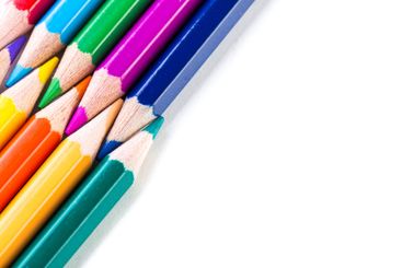 Vibrant colored pencils arranged on a white surface...