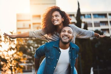 Piggy back, happy and couple in city in morning for fun,...