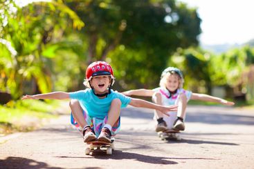 Kid with skateboard. Child riding skate board.