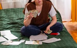 Close up of young woman reviewing bills planning savings...