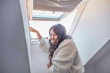 woman, bathed in the natural light from above,...