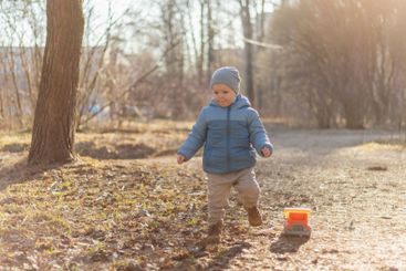 Happy baby child outdoor. Little toddler boy with toy...