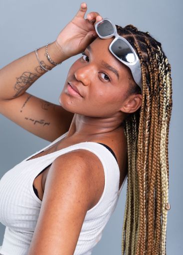 Beautiful brunette with braids in her hair, holding...