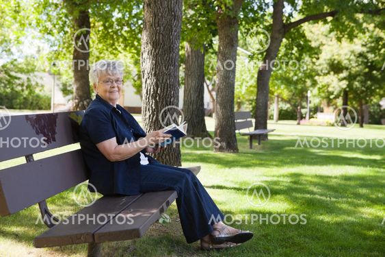 Woman reading book in a park