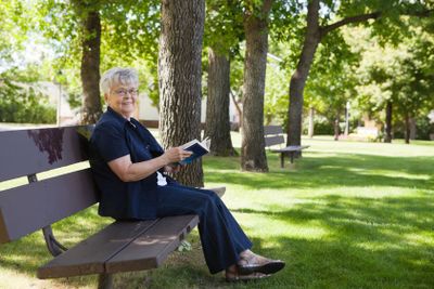 Woman reading book in a park