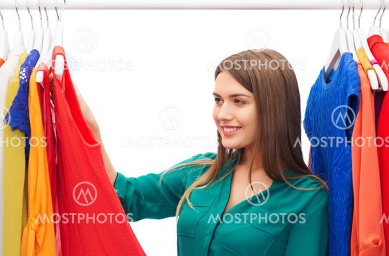 happy woman choosing clothes at home wardrobe