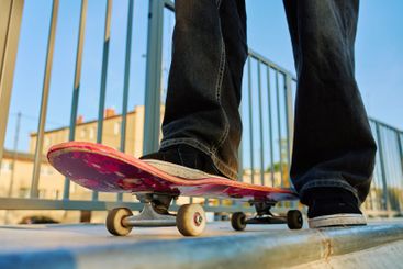 Skateboarder riding on pink skateboard at skatepark