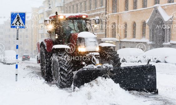 Plow removing snow from city street in Stockholm.