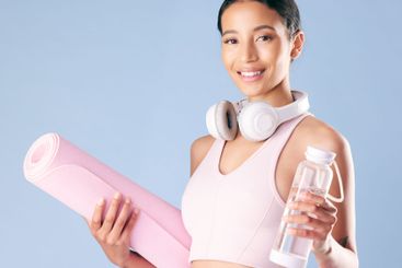 Fitness, woman and water with yoga mat in studio for...
