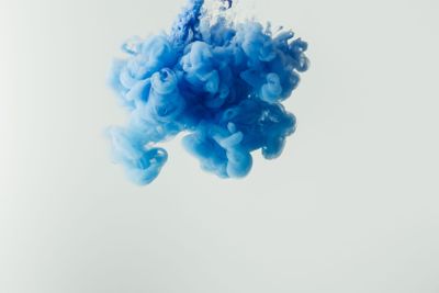close up shot of bright blue paint splash in water...