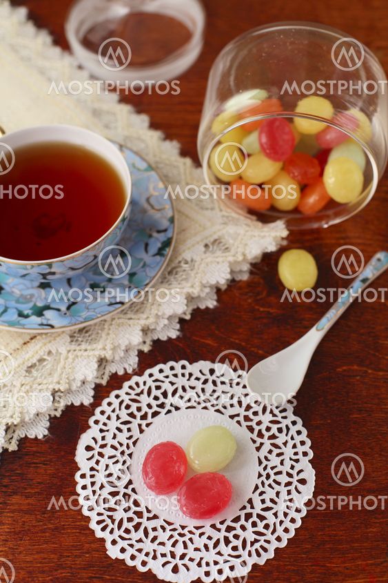 Tea with coloured sugar candies in a glass can