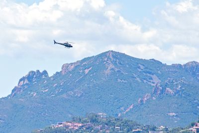 Daylight view to helicopter flying above mountains with...