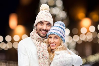 happy couple hugging over christmas lights