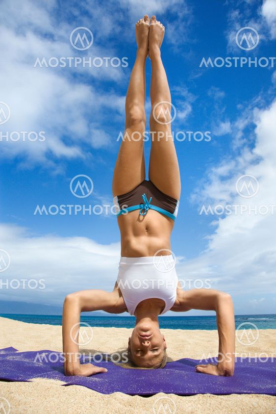 Woman doing yoga on beach.