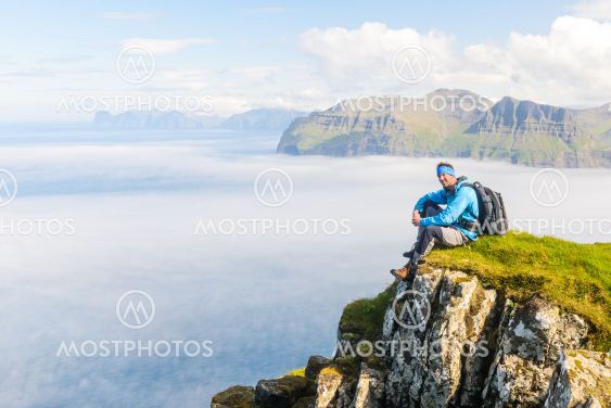 Hiker sitting with a view. Mykines, Faroe Islands