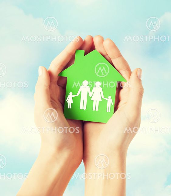 hands holding green house with family