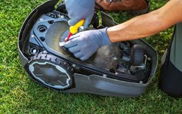 Repairing a Robotic Lawn Mower on Grassy Turf in the...
