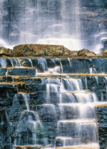 Blurry water on rocks by a waterfall