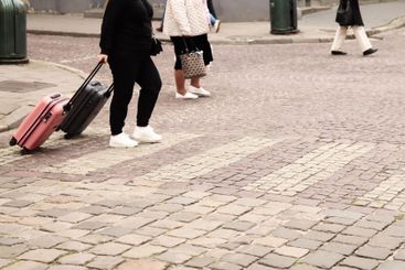 People with suitcases walking, city travel. Women with...