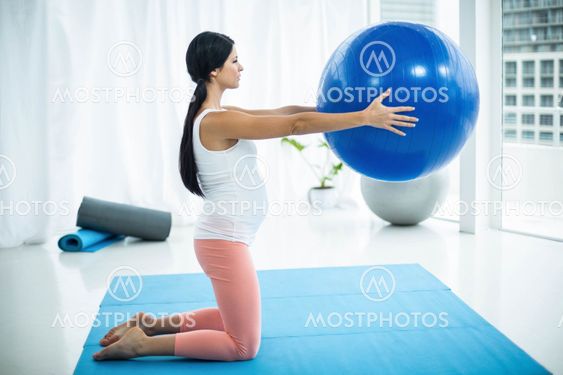 Pregnant woman exercising with exercise ball