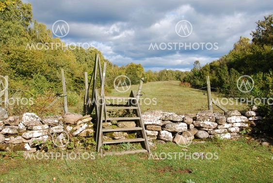 Wooden stile by a stone wall