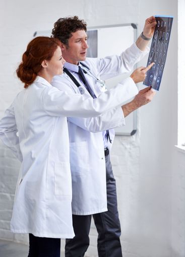 Doctors, brain scan and check results at clinic with...