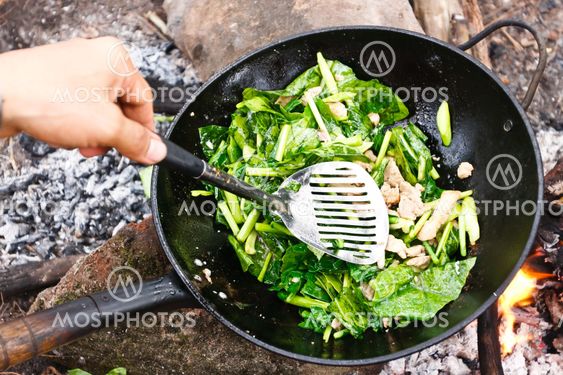 Cooking vegetables and meat in wok pan