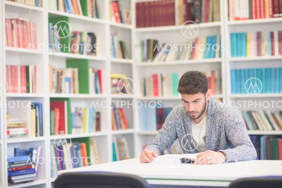 portrait of student while reading book in school library