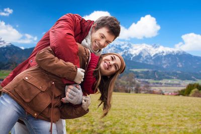 happy young couple having fun over alps mountains