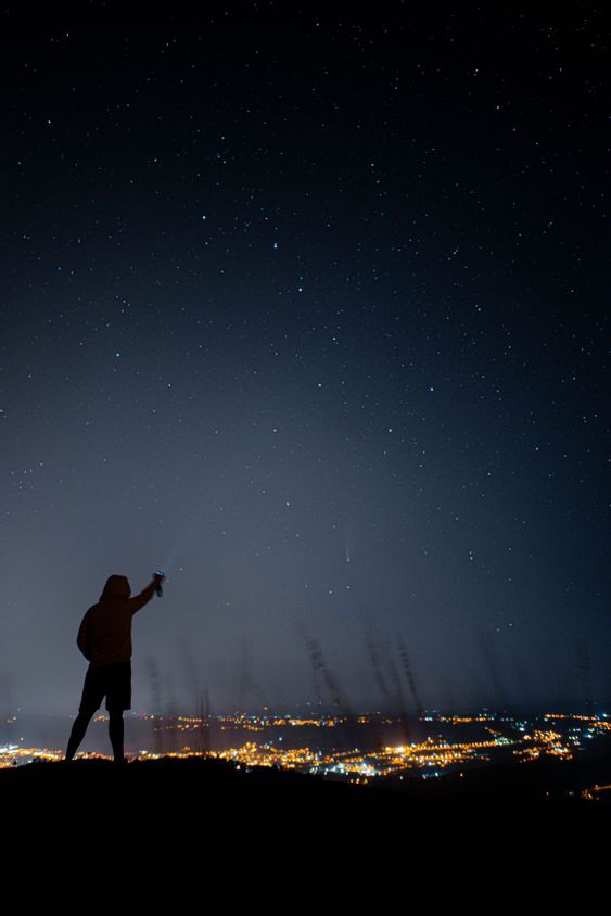 una persona apuntando al cometa neowisse