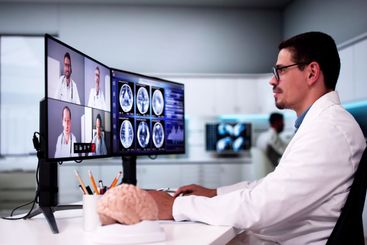Doctors In Clinic Looking At Brain MRI Scan
