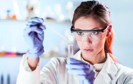 Young scientist pipetting in life science laboratory.