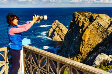Tourist with camera on Asturias coast, Spain