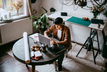 High angle view of male freelancer working on laptop...