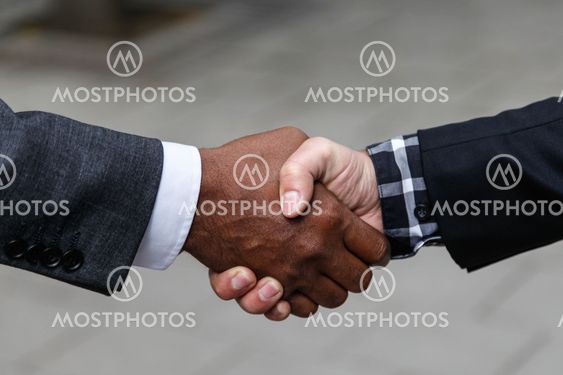 Handslag mellan svart och vit man